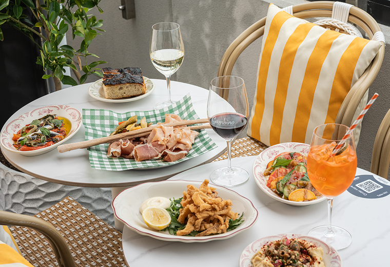 Rooftop dining setup with Italian dishes and cocktails