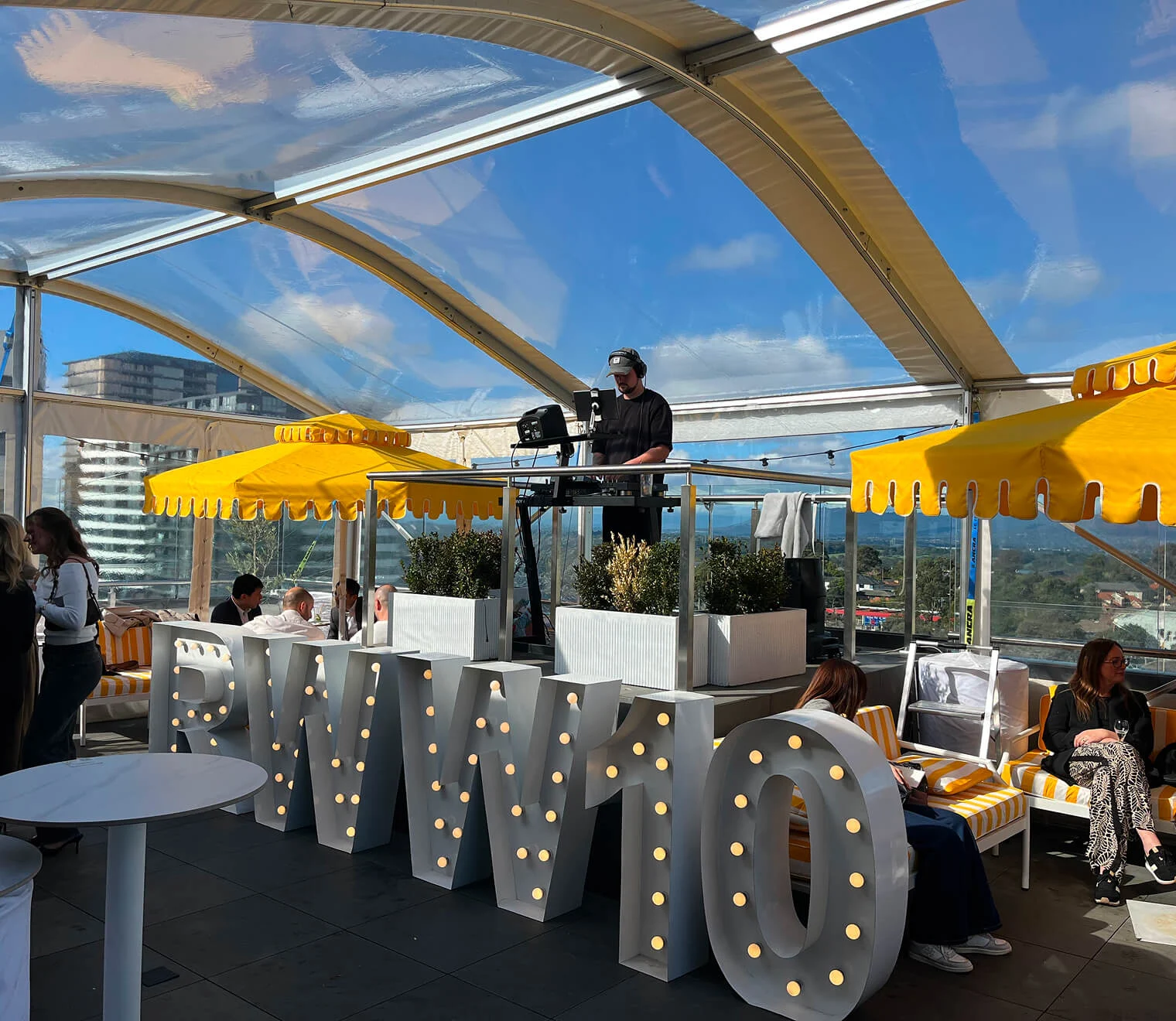 Guests enjoying drinks on the rooftop at sunset